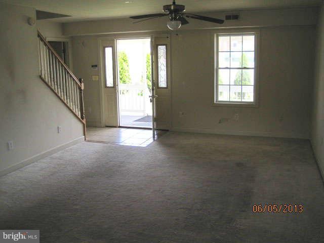 8009 Shore Road Baltimore, MD 21222 - Photo 8 of 19 an empty room with windows and a ceiling fan