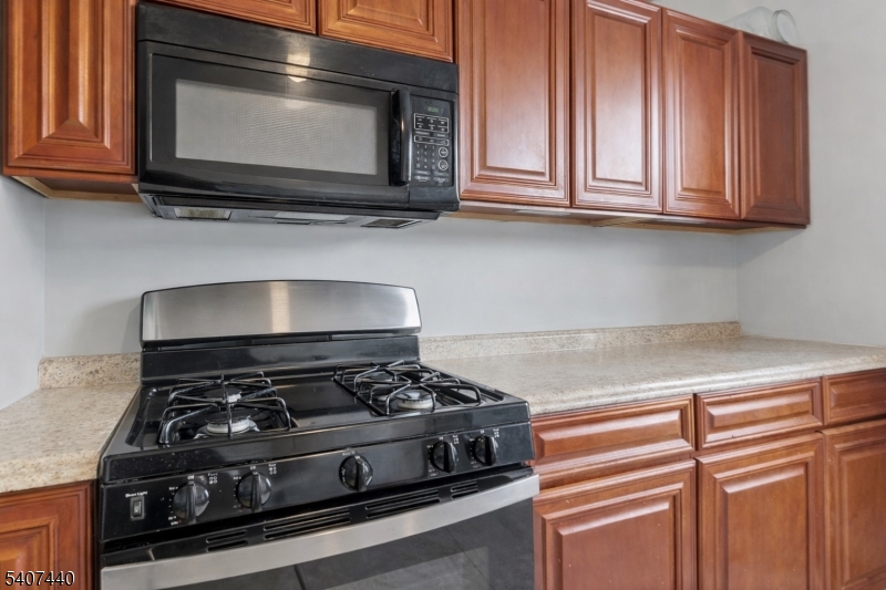 105 Huntington Terrace Newark, NJ 07112 - Photo 16 of 20 a kitchen with stainless steel appliances granite countertop a stove and a microwave