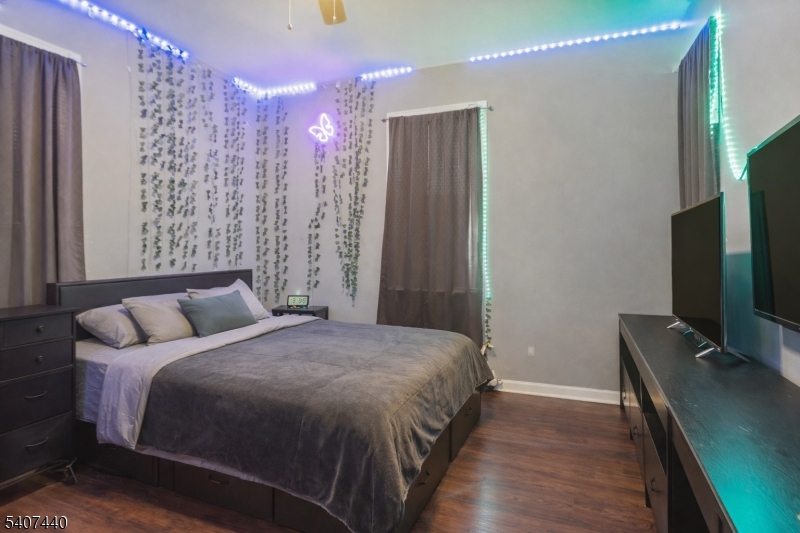 105 Huntington Terrace Newark, NJ 07112 - Photo 5 of 20 a bedroom with a bed window and a flat tv screen on a dresser