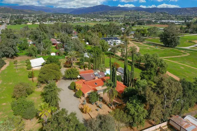 an aerial view of a house with a yard and lake view