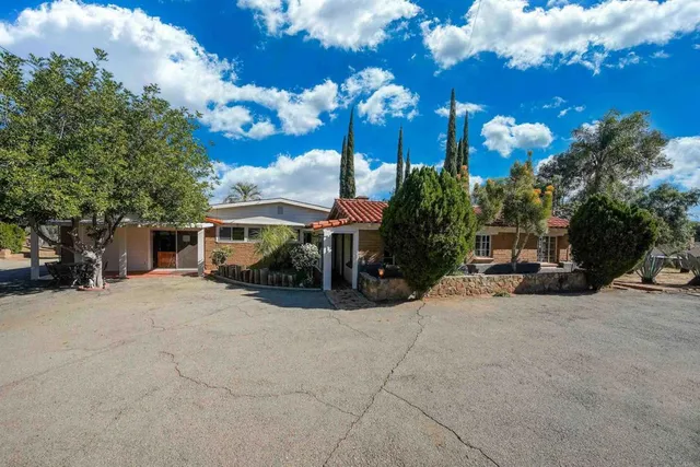 a view of a house with backyard and sitting area