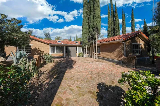 a view of a house with backyard and sitting area