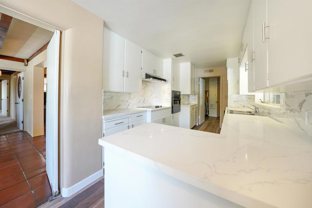 1077 Pine Street Ramona, CA 92065 - Photo 8 of 51 a large white kitchen with a refrigerator a sink dishwasher and a refrigerator with wooden floor