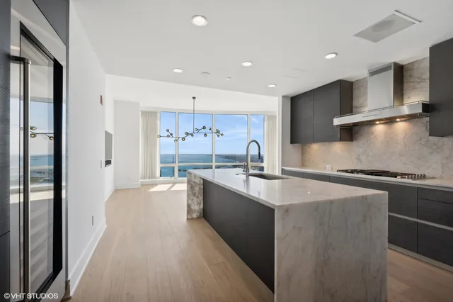 a large kitchen with stainless steel appliances granite countertop a lot of counter space and a sink