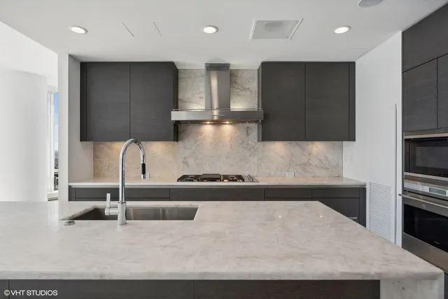 a kitchen with kitchen island granite countertop a stove and a refrigerator