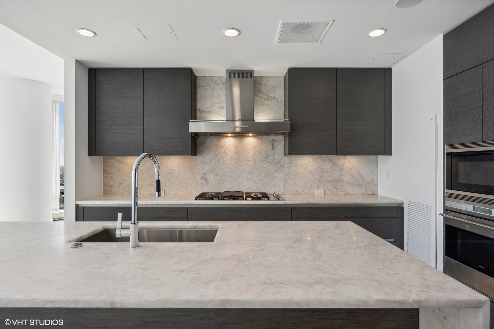 401 North Wabash Avenue, Unit 69E Chicago, IL 60611 - Photo 15 of 62 a kitchen with kitchen island granite countertop a stove and a refrigerator