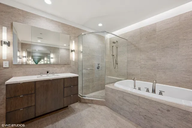 a large bathroom with a tub sink shower and mirror