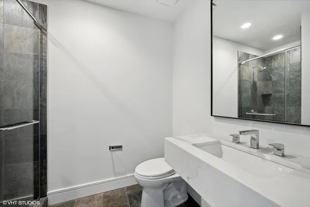 a bathroom with a granite countertop sink toilet and shower
