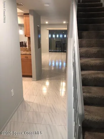 a view of a hallway with wooden floor and staircase