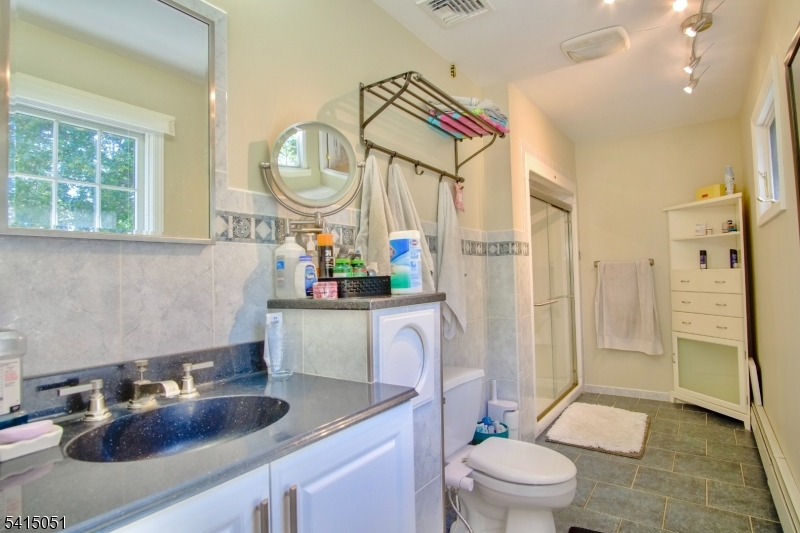 4 Budd Street Ledgewood, NJ 07852 - Photo 9 of 22 a bathroom with a sink a toilet and a large mirror