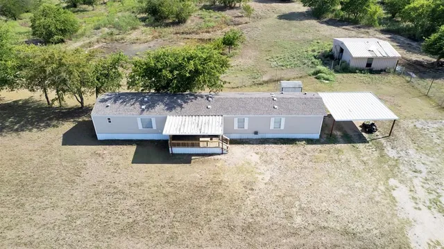 an aerial view of a house with yard and car parked