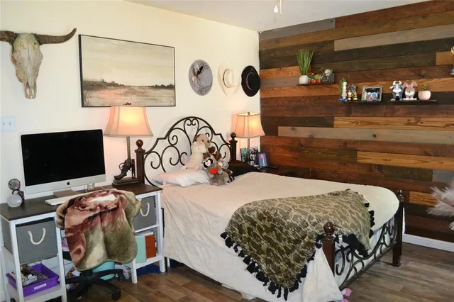 a bedroom with a bed and a flat tv screen on the dresser