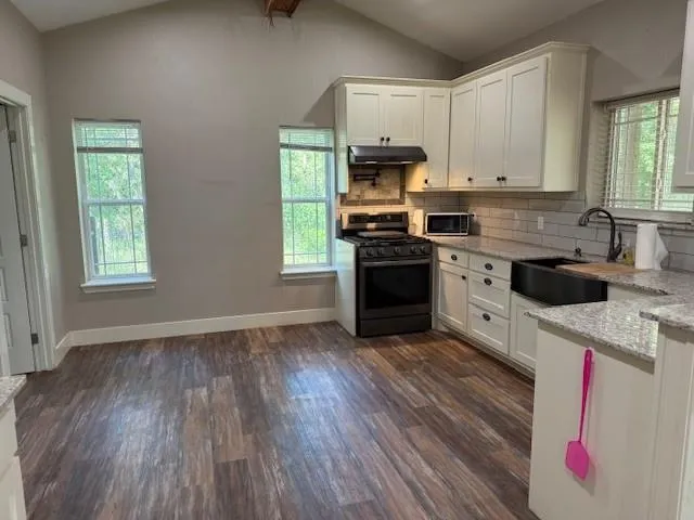 a kitchen with stainless steel appliances granite countertop a stove a sink and a refrigerator