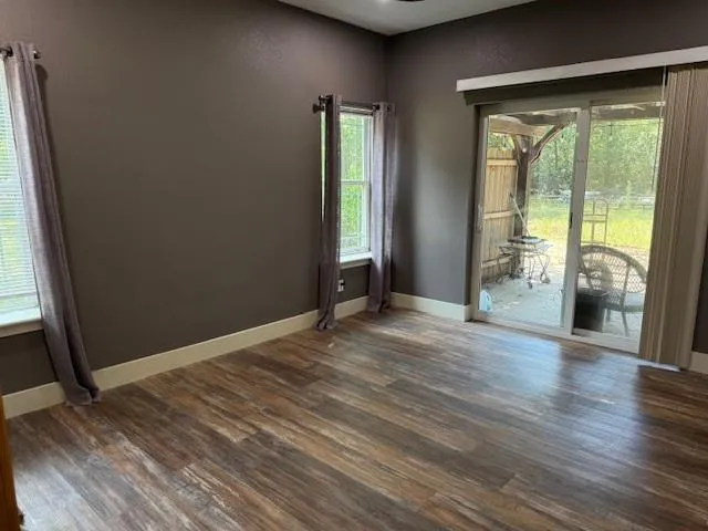 an empty room with wooden floor and a window