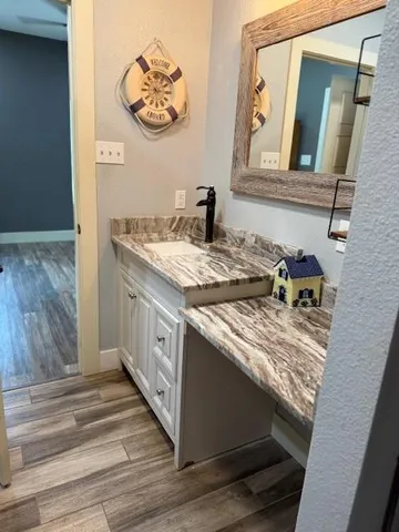 a bathroom with a granite countertop sink and a mirror