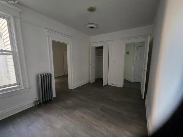 an empty room with wooden floor and door