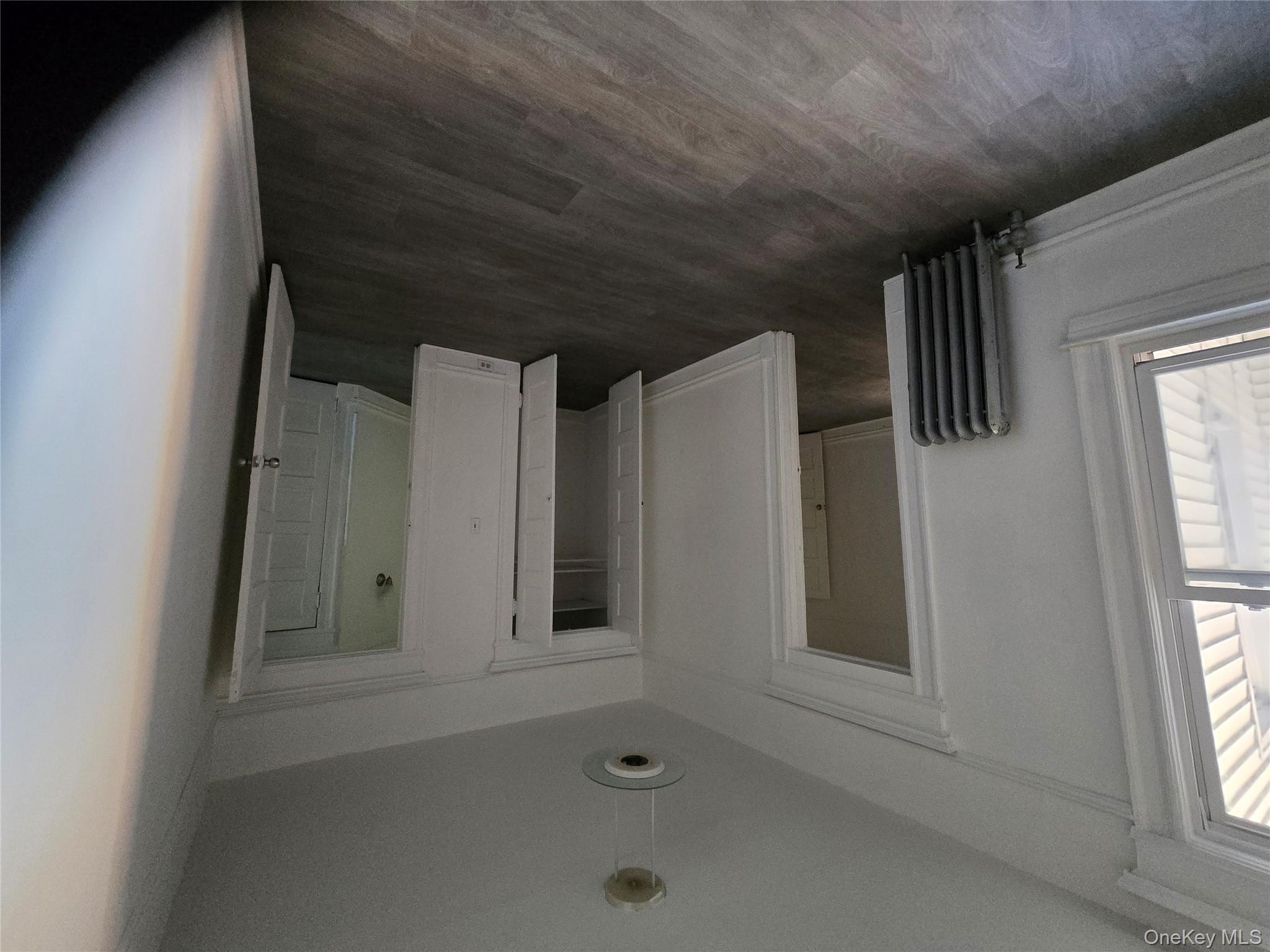 67 Radford Street, Unit 2E Yonkers, NY 10705 - Photo 13 of 19 an empty room with wooden floor and windows