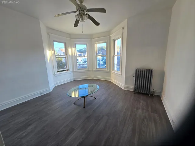 a view of a livingroom with wooden floor and a window