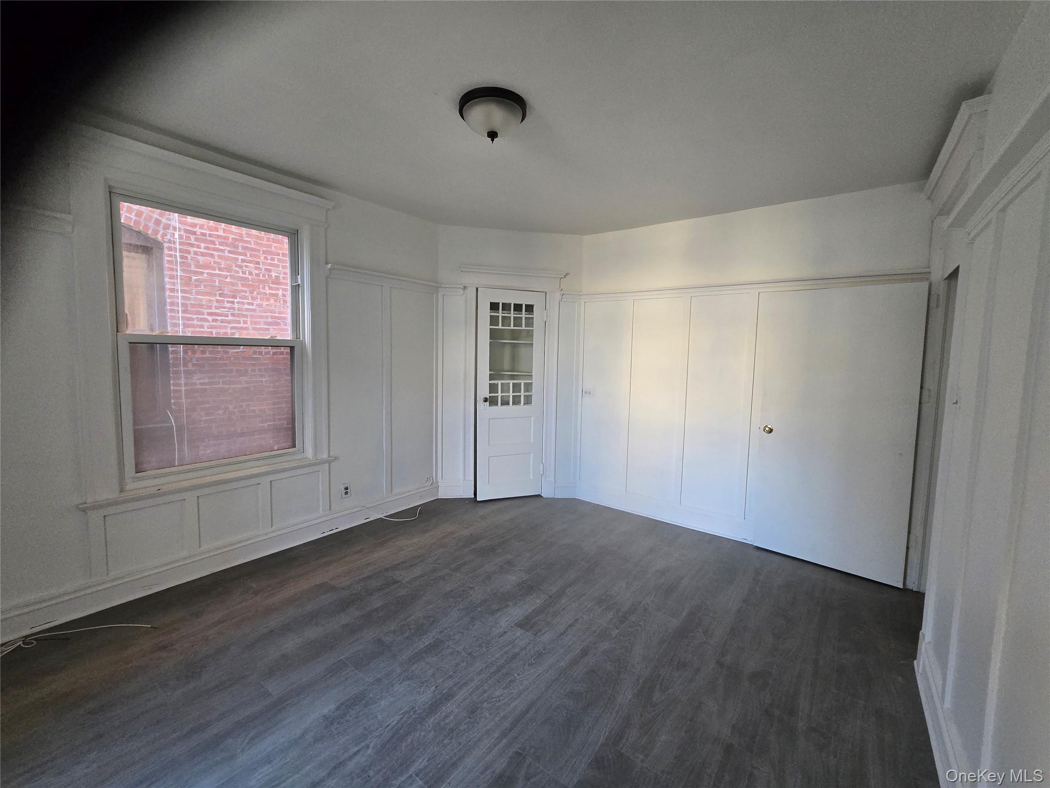 67 Radford Street, Unit 2E Yonkers, NY 10705 - Photo 4 of 19 a view of an empty room with wooden floor and a window