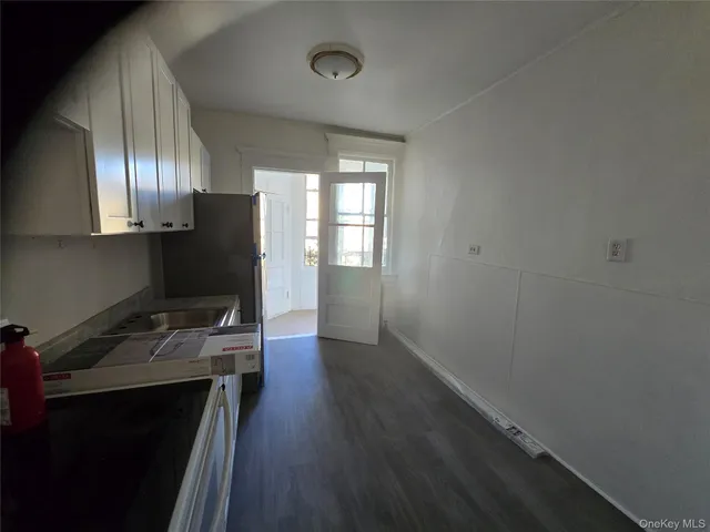 a kitchen with a refrigerator and wooden floor
