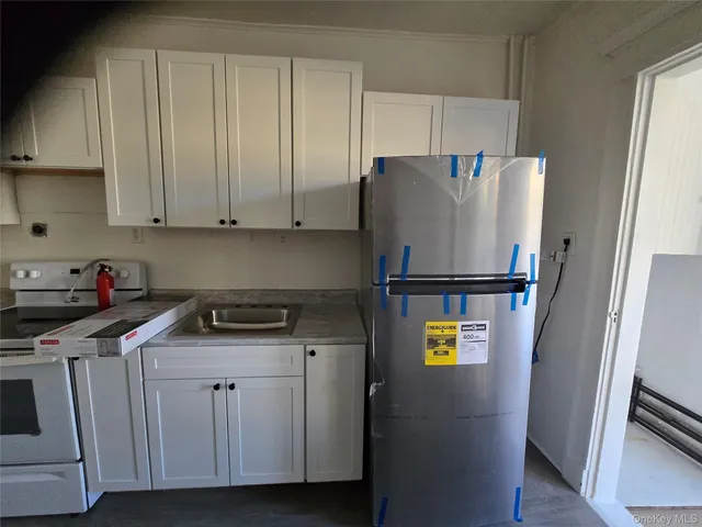 a kitchen with a refrigerator and a stove top oven
