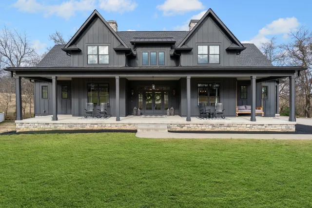 a view of a white house with swimming pool and a table of chairs