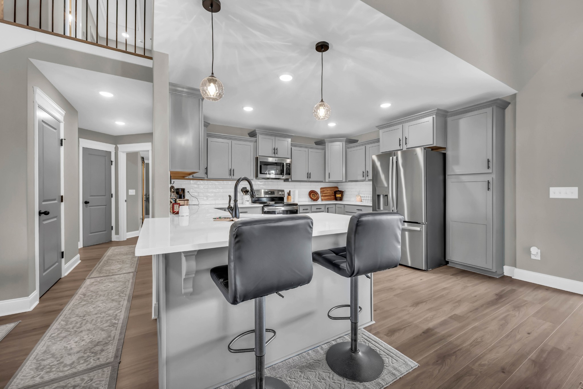 834 Limestone Way Clarksville, TN 37043 - Photo 12 of 26 a kitchen with stainless steel appliances kitchen island granite countertop a refrigerator a stove a kitchen island a dining table and chairs with wooden floor
