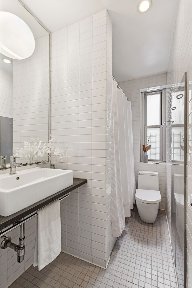 180 West 93rd Street, Unit 2E Manhattan, NY 10025 - Photo 12 of 20 a bathroom with a sink toilet and shower