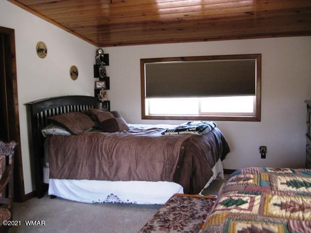 2091 Ranger Road Overgaard, AZ 85933 - Photo 31 of 66 a bed sitting in a bedroom next to a window