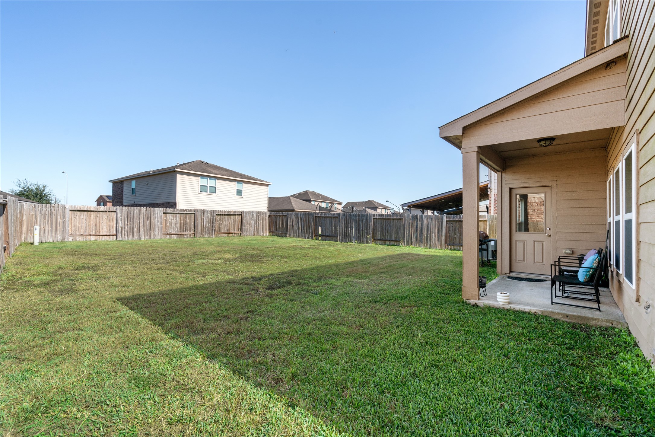 2011 Beach Bluff Road Rosenberg, TX 77469 - Photo 32 of 34 This cozy backyard features a small covered patio, creating a perfect spot for shaded relaxation. The compact outdoor space is ideal for a bistro set or small gathering, offering just the right blend of comfort and privacy.
