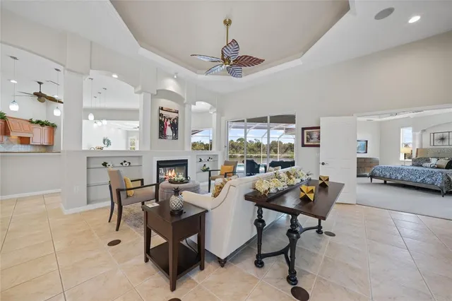a bedroom with a large bed and a chandelier fan