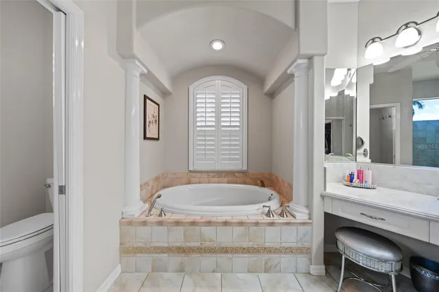 a kitchen with stainless steel appliances kitchen island granite countertop a refrigerator a stove top oven and a sink with island