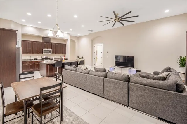 a living room with furniture kitchen view and a chandelier