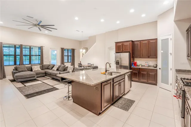 a large white kitchen with a large window and stainless steel appliances