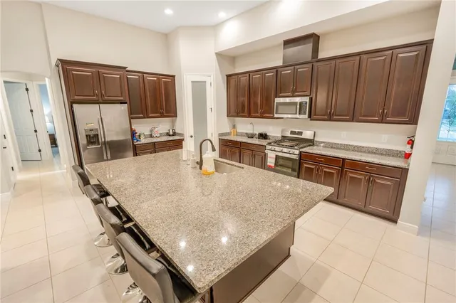 a kitchen with stainless steel appliances granite countertop a stove a sink a microwave and a refrigerator