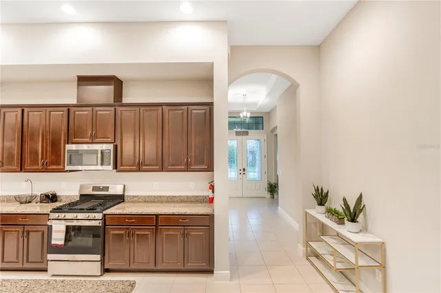 a kitchen with stainless steel appliances granite countertop a stove a sink and a microwave