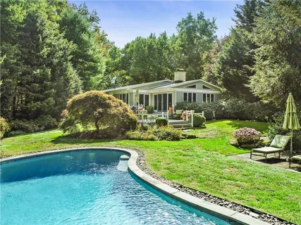 a view of a house with swimming pool and a yard