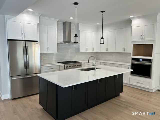 35 Village Circle, Unit 35 Hamden, CT 06514 - Photo 5 of 14 a kitchen with stainless steel appliances granite countertop a sink a stove a refrigerator and island with wooden floor