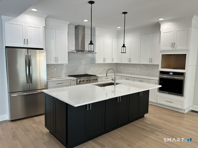 35 Village Circle, Unit 35 Hamden, CT 06514 - Photo 6 of 14 a kitchen with stainless steel appliances granite countertop a sink a stove a refrigerator and island with wooden floor