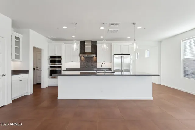 a large kitchen with kitchen island a stove a sink a center island and windows