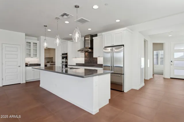 a kitchen with stainless steel appliances granite countertop a sink and a refrigerator