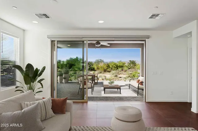 a living room with furniture a flat screen tv and a large window