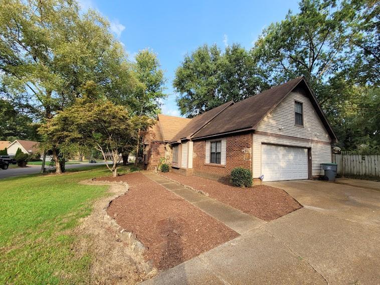 5285 Orangewood Road Memphis, TN 38134 - Photo 3 of 25 This view shows the two-car side-load garage with overflow parking. The garage features a new Chamberlin garage door system with outdoor keypad, and there is gated entrance to the backyard from this space as well.
