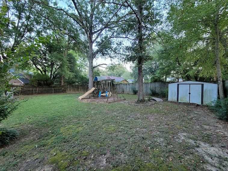 5285 Orangewood Road Memphis, TN 38134 - Photo 24 of 25 The backyard gives plenty of room to enjoy, has some mature trees offering great shady, cool spots, a storage building, a play swing/set for children and a rear patio. The yard is also fully fenced.