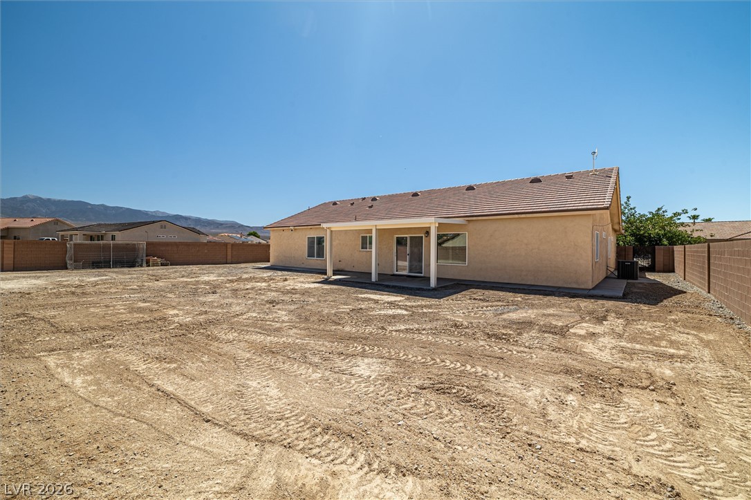 6720 Stubblefield Drive Pahrump, NV 89061 - Photo 35 of 51 A spacious, bare yard awaits customization, with a covered patio for future outdoor enjoyment.