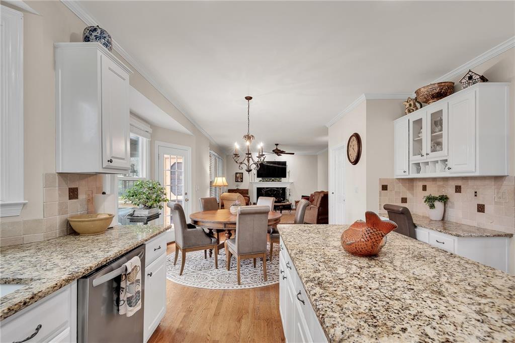 520 Fawn Run Alpharetta, GA 30005 - Photo 19 of 65 a kitchen with stainless steel appliances granite countertop a stove top oven a sink a dining table and chairs with white cabinets