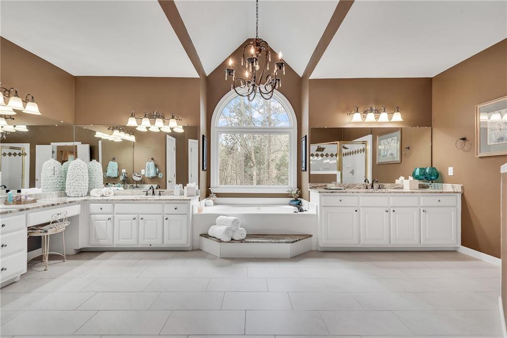 520 Fawn Run Alpharetta, GA 30005 - Photo 43 of 65 a large bathroom with a granite countertop sink a large mirror and a bathtub