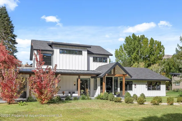 a kitchen with stainless steel appliances granite countertop a stove a refrigerator a kitchen island a table and chairs in it