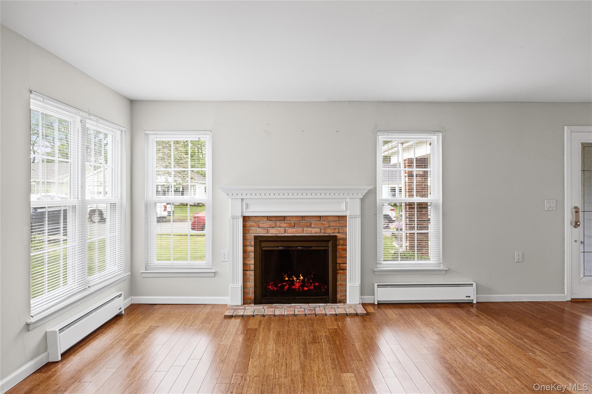 220 Belfast Lane Ridge, NY 11961 - Photo 13 of 44 a view of an empty room with wooden floor fireplace and a window