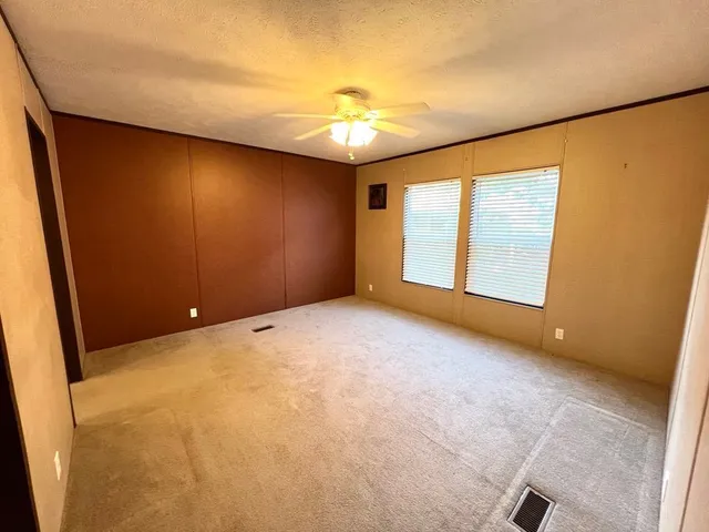 a kitchen with stainless steel appliances kitchen island granite countertop a table chairs and a refrigerator